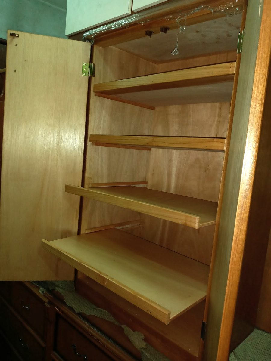 Interior de un ropero de madera con estantes extraíbles